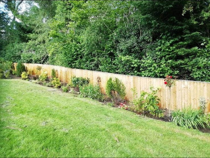 The same fence line planted the whole way along, with the lawn mown to the edge