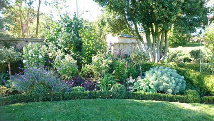 A deep mixed border kept in shape behind clipped box edging