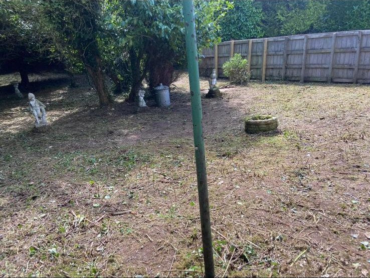 The same plot cleared to bare ground, uncovering statues and mature yews