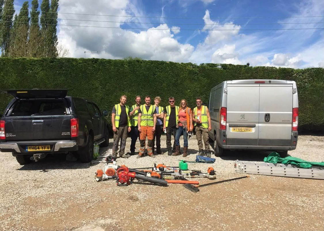 The Hocus Crocus team in hi vis beside the vans, with the tools laid out