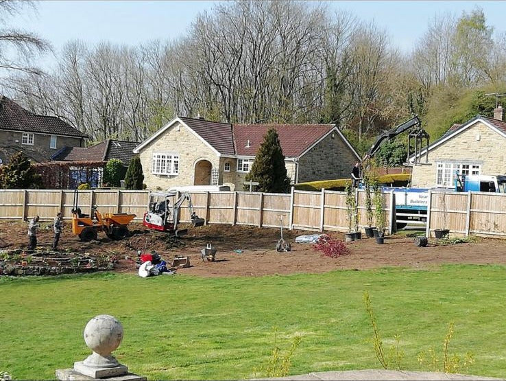 A new build estate garden being dug out and levelled by mini digger