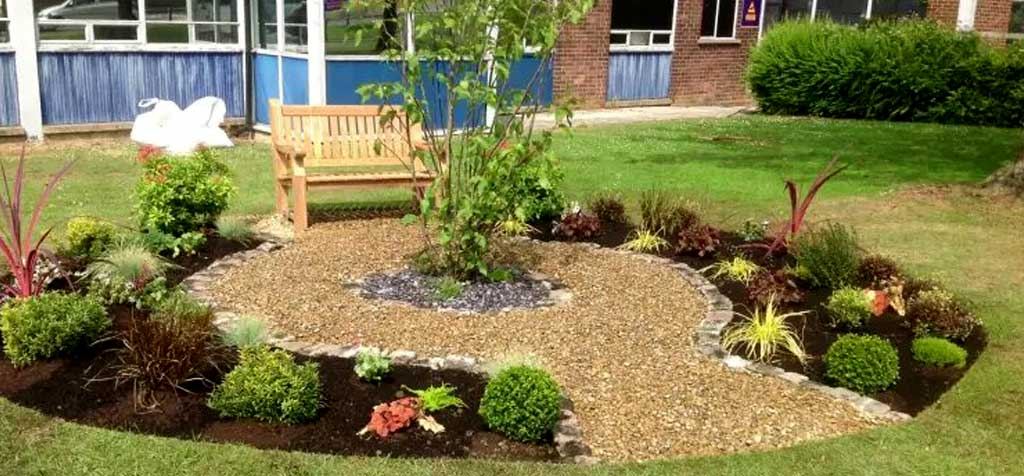 A memorial garden with planted beds and a seating area