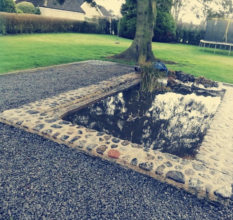 The same pond after clearing, the water clear and the cobbled stone surround jet washed